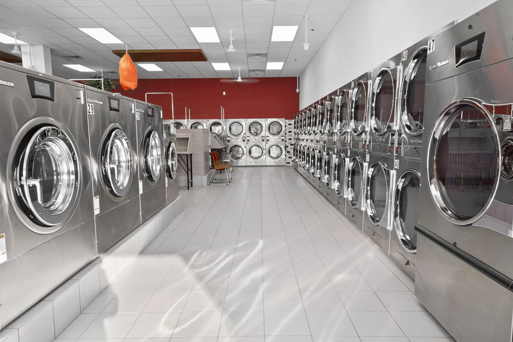 Rows of commercial washers inside a LaundroMax store